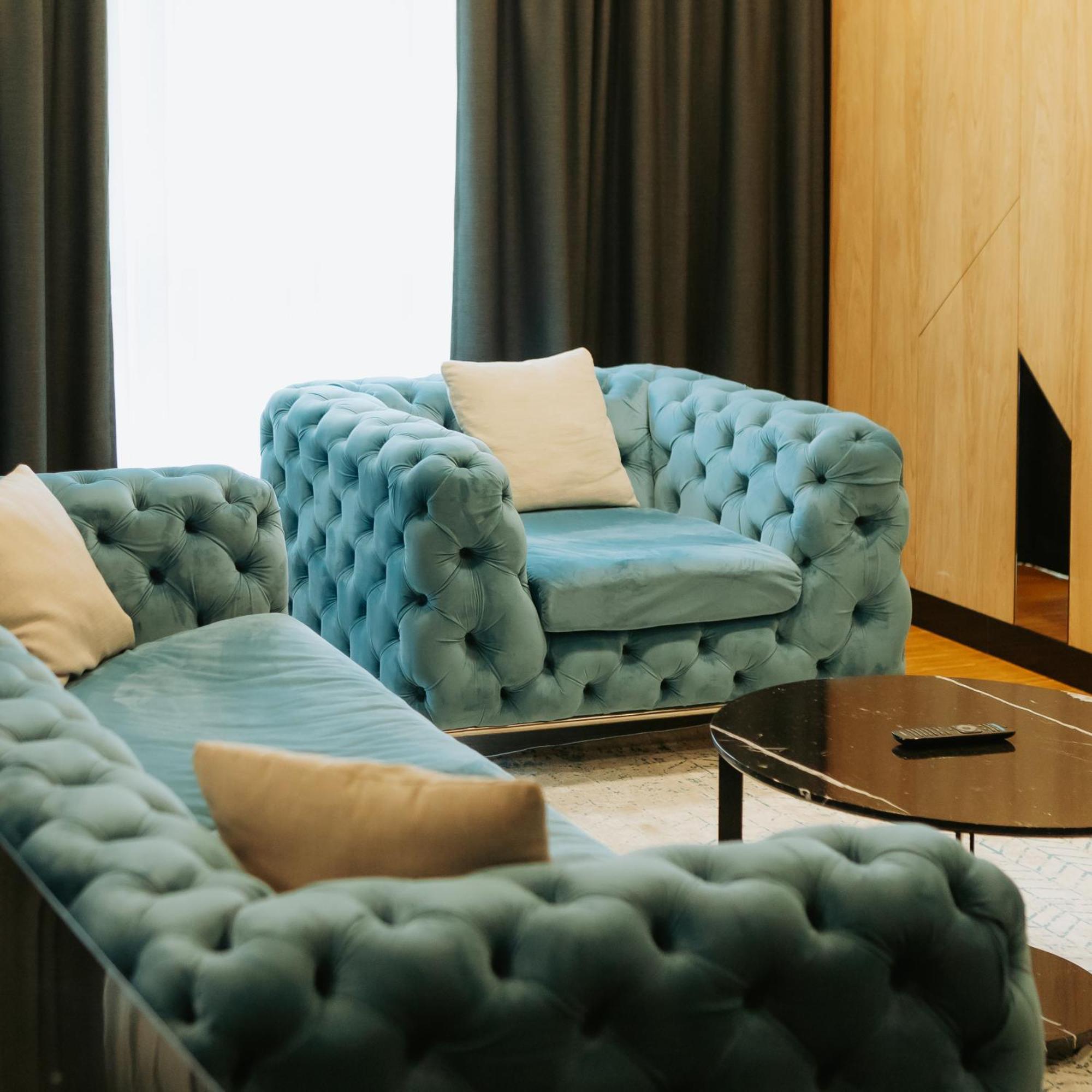 Hotel Platinia Kaloşvar Dış mekan fotoğraf A blue velvet Chesterfield sofa
